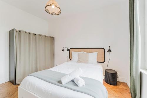 a bedroom with a white bed with two towels on it at La Madeleine -two bedroom apartment in La Madeleine