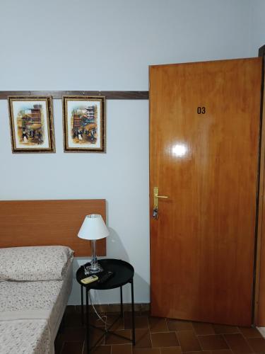 a room with a door and a table with a lamp at ZAHRA ARAGONA in Aragona