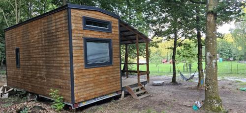 a tiny house sitting in the middle of a forest at Domek na Kaszubach w Potęgowie in Kamienicki Młyn