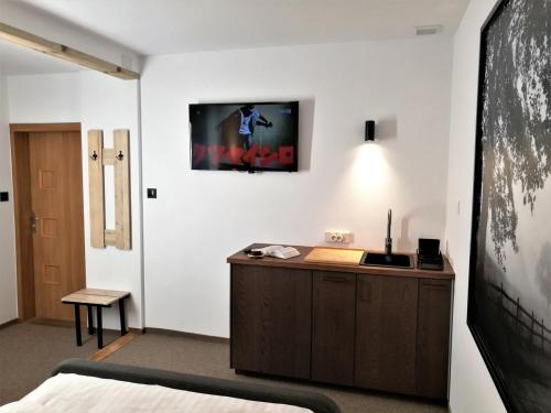 a bedroom with a bed and a tv on the wall at Hotel Protea Bolesławiec in Bolesławiec