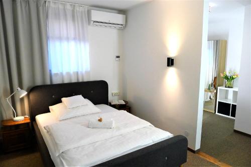 a bedroom with a bed with white sheets and a window at Hotel Protea Bolesławiec in Bolesławiec