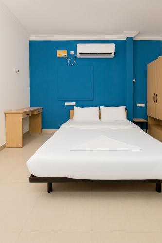 a large bed in a room with a blue wall at Hotel Shanti Regency in Pune
