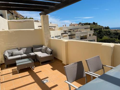 patio z kanapą i krzesłami na balkonie w obiekcie Benalmadena Home w mieście Benalmádena