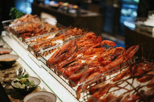 a buffet of lobsters in trays on a table at JW Marriott Hotel and Suites Saigon in Ho Chi Minh City