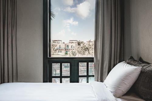 a bedroom with a bed and a large window at Cook’s Club El Gouna (Adults Only) in Hurghada