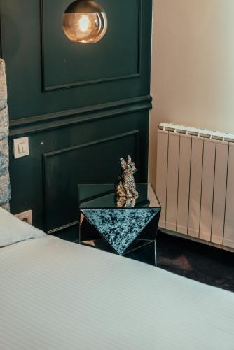 a cat sitting on a table next to a bed at BW Cityline Residences in Belgrade