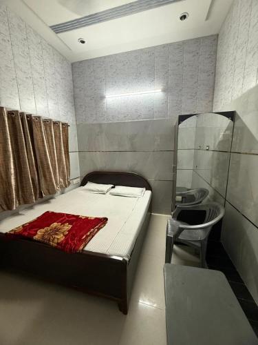 a bedroom with a bed and a chair and a sink at Kalindi Blessings Deluxe Guest House in Mathura