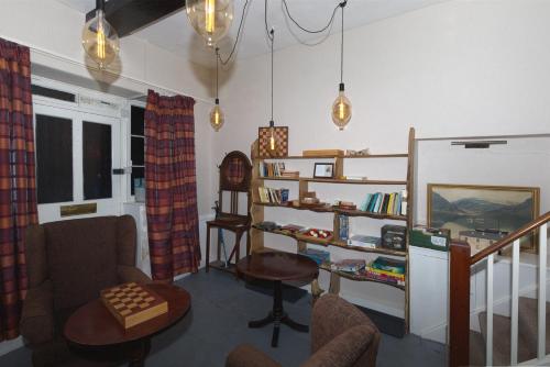 a living room with chairs and a table and shelves at Rydal Lodge in Rydal