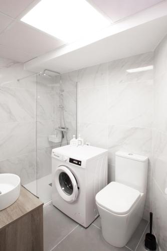 a bathroom with a washing machine and a toilet at Eliss apartment in Costa de Adeje