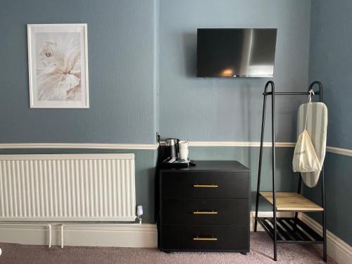 a room with a black dresser and a chair at Wedgwood Hotel - Room 4 in Llandudno