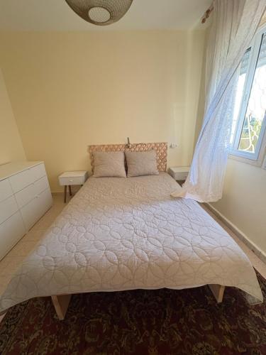 a large bed in a bedroom with a window at המצפאית in Mitzpe Ramon
