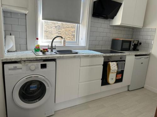 a kitchen with a washing machine and a sink at Church View house,2bed,brighouse central location in Brighouse