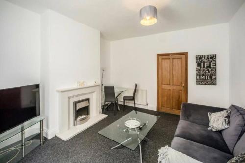 a living room with a couch and a fireplace at Church View house,2bed,brighouse central location in Brighouse