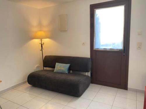 a room with a chair and a lamp and a window at super appartement in Bouguenais
