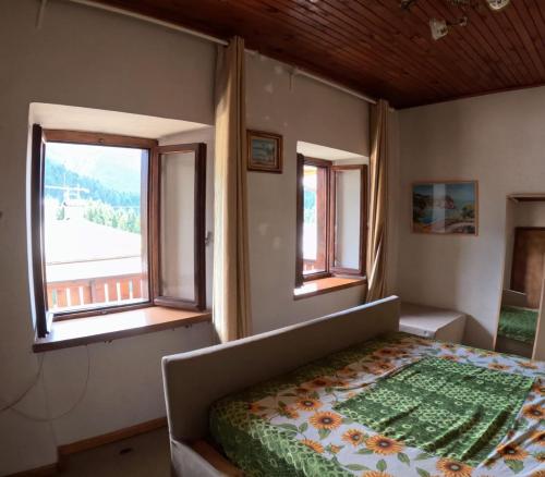una camera da letto con un letto e due finestre di Rium Mare & Monti a Pieve di Cadore