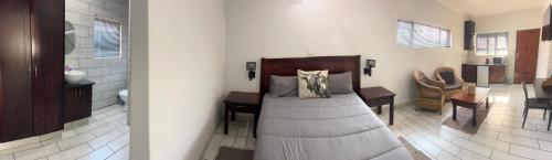 a bedroom with a bed and a desk and a bathroom at Twee Wilgers Bed & Breakfast in Randfontein