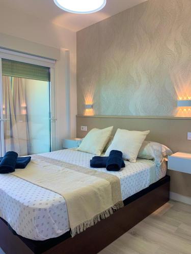 a bedroom with a large bed with blue towels on it at Apto LUXURY BONAIRE in Puerto de Gandía