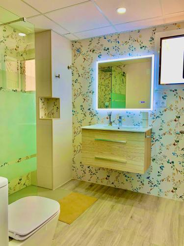 a bathroom with a toilet and a sink and a mirror at Apto LUXURY BONAIRE in Puerto de Gandía