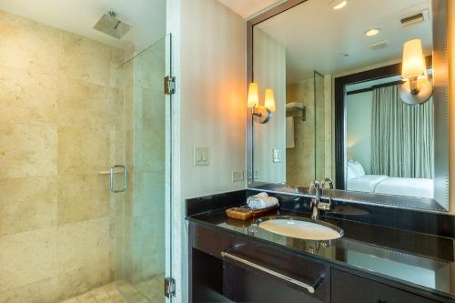 a bathroom with a sink and a shower and a mirror at SBV Luxury Ocean Hotel Suites in Miami Beach