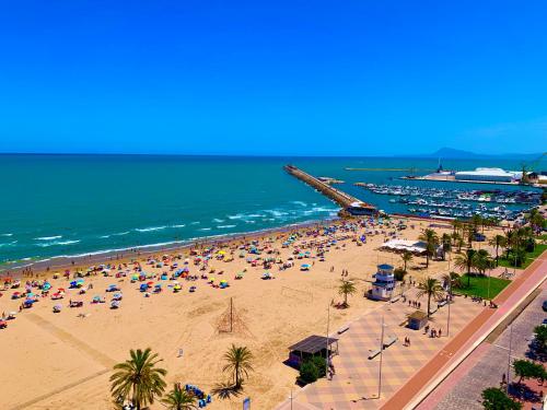 einen Strand mit vielen Menschen und dem Meer in der Unterkunft Apto LUXURY BONAIRE in Puerto de Gandía