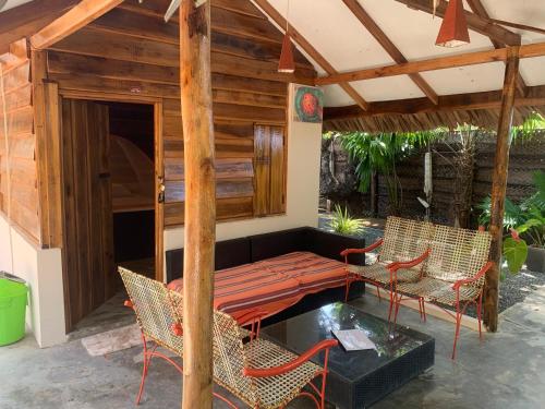 a patio with a couch and chairs and a table at The Tasty Tuna Cabana in Arugam Bay