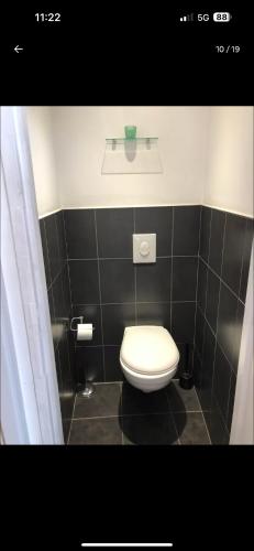 La salle de bains est pourvue de toilettes et d'un mur carrelé noir. dans l'établissement Studio Metz centre, à Metz