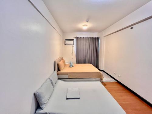 a small room with a bed and a couch at 3 Bedroom Spacious Davao Condo in Davao City
