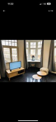 une pièce avec un ordinateur portable, deux tables et des fenêtres dans l'établissement Studio Metz centre, à Metz