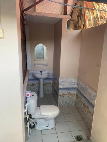 a bathroom with a toilet and a sink at The Tasty Tuna Cabana in Arugam Bay