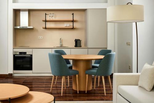 a kitchen with a wooden table and blue chairs at Marriott Residences Salgados Resort, Algarve in Albufeira