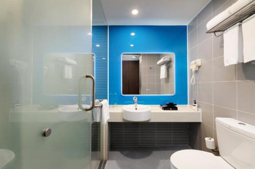 a bathroom with a sink and a toilet and a mirror at Holiday Inn Express Chengdu Wuhou by IHG-Wuhou Temple and Jinli in Chengdu