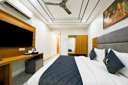 a bedroom with a large bed and a flat screen tv at Premium Lee Premier in New Delhi