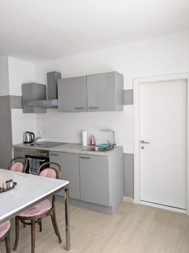 a kitchen with white cabinets and a table and chairs at Apartment in Schottwien