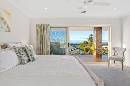Un dormitorio con una cama y una puerta corrediza de vidrio. en The Dromana Beach House - Stunning Views, en Dromana