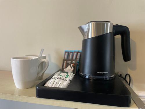a coffee maker sitting on a counter next to a cup at Wedgwood Hotel, Seascape Room in Llandudno