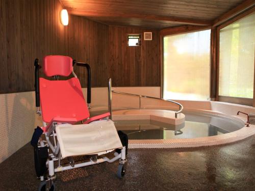 a hospital room with a chair and a bed at Suikoen in Kawanehon
