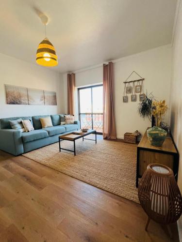 a living room with a blue couch and a table at Apartamento Brisa Vicentina- Odeceixe in Odeceixe