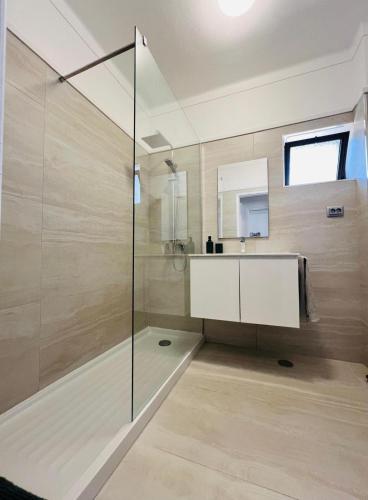 a bathroom with a glass shower and a sink at Apartamento Brisa Vicentina- Odeceixe in Odeceixe