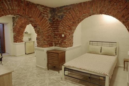 a bedroom with a bed and a brick wall at Hello Sofia Guesthouse in Sofia