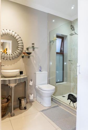 a bathroom with a toilet and a sink and a shower at Earthbound Guest House in Oudtshoorn