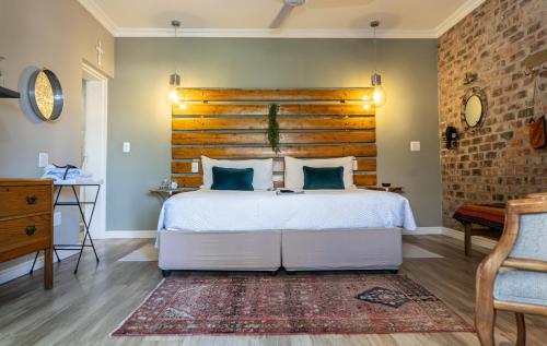a bedroom with a large bed with a wooden headboard at Earthbound Guest House in Oudtshoorn