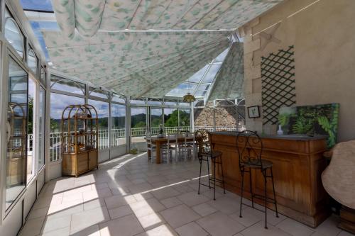 a conservatory with a table and chairs on a patio at Chambre D'hôtes Vignols in Vignols