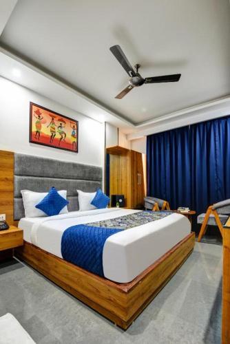 a bedroom with a large bed with blue pillows at Airport Le Premier, New Delhi in New Delhi