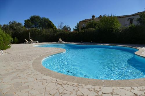 Una piscina con agua azul en un patio. en Appartement clim & piscine sur Golf, en Pont-Royal