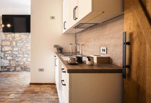 a kitchen with white cabinets and a wooden counter top at Lipa Plac in Postojna