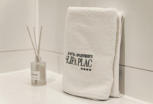 a white towel sitting on a counter next to a vase at Lipa Plac in Postojna
