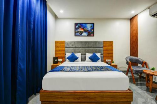 a bedroom with a large bed with blue curtains at Airport Le Premier, New Delhi in New Delhi