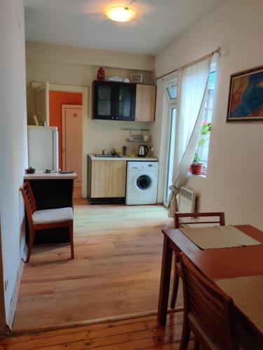 a living room with a kitchen with a refrigerator and a table at Hello Sofia Guesthouse in Sofia