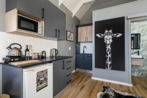 a kitchen with a giraffe painting on the wall at Kragga Kamma Game Park in Port Elizabeth