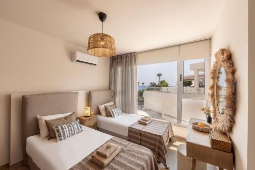 une chambre d'hôtel avec deux lits et un balcon dans l'établissement Pallini 202, à Protaras